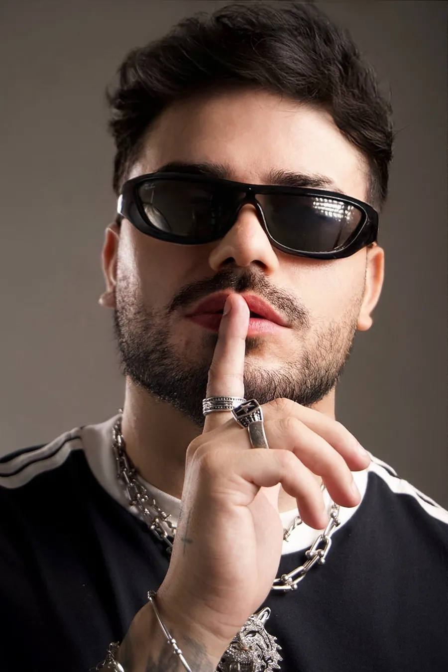 DJ Toledo de óculos escuros pedindo silêncio