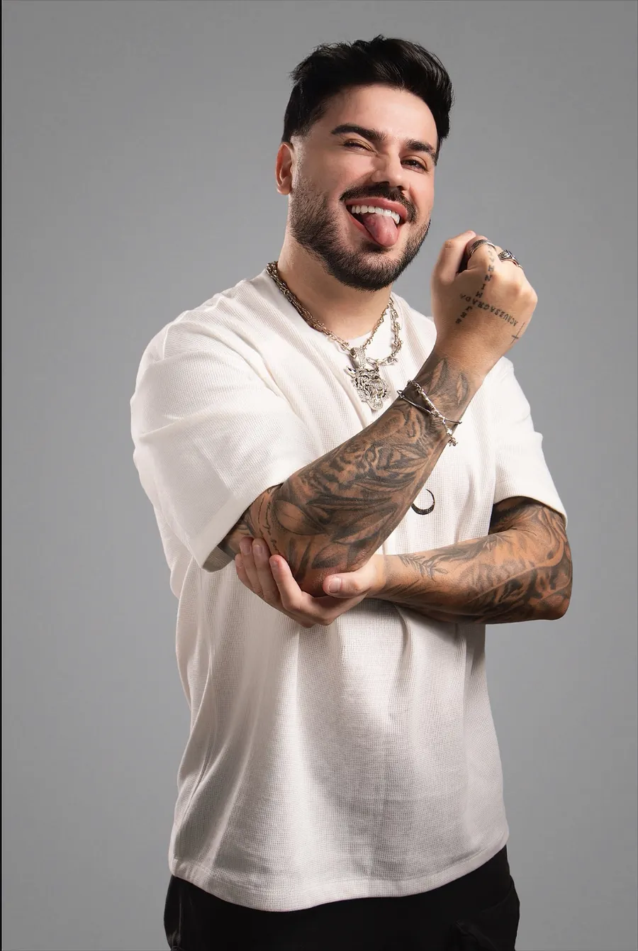 DJ Toledo sorrindo de camiseta branca