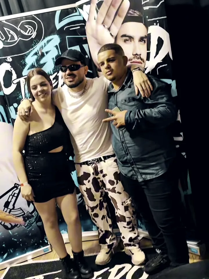 Fãs tirando foto com o DJ Toledo na frente do backdrop